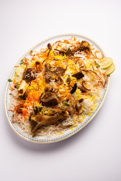 Hammel- oder Lammbiriyani mit Basmatireis, serviert in einer Schüssel über stimmungsvollem Hintergrund.