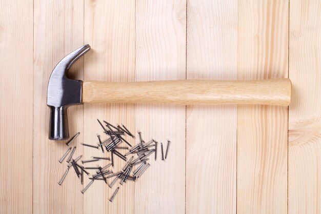 Foto hammer mit nagel auf holzhintergrund