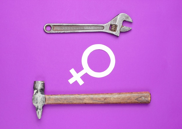 Hammer, Schraubenschlüssel, Symbol der Feministin auf lila Hintergrund