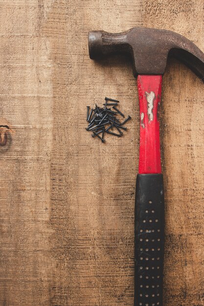 Hammer und schwarze Nägel auf Holztisch. Alte Werkzeuge. Speicherplatz kopieren.