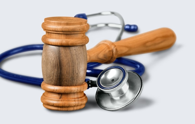 Hammer und Stethoskop im Hintergrund, Symbolfoto für Pfusch und medizinische Fehler