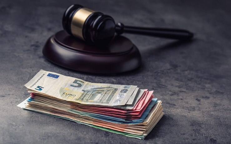 Hammerhammer des Richters. Gerechtigkeit und Euro-Geld. Euro Währung. Gerichtshammer und gerollte Euro-Banknoten. Darstellung von Korruption und Bestechung in der Justiz.