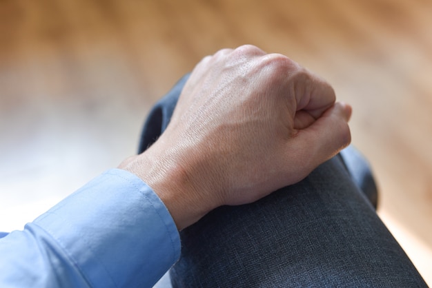 Hand auf dem Knie eines Bürovorstehers