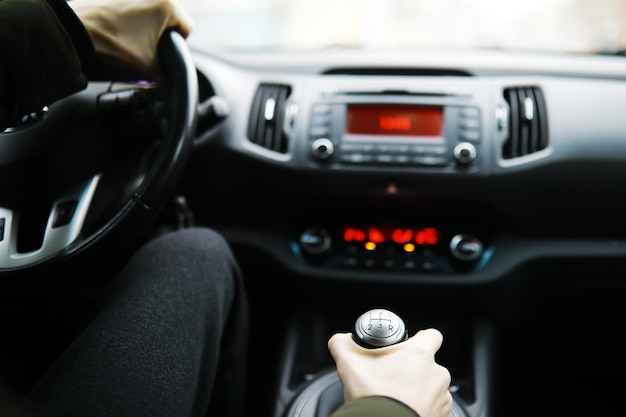 Hand auf den Schaltknauf des Autos. Der Fahrer schaltet die Geschwindigkeit im Auto. Hand am Schalthebel.