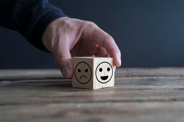 Hand berühren wählen Sie Lächeln Gesicht Emotion des Holzwürfelblocks Bewertungskonzept Wahl des glücklichen positiven Symbols