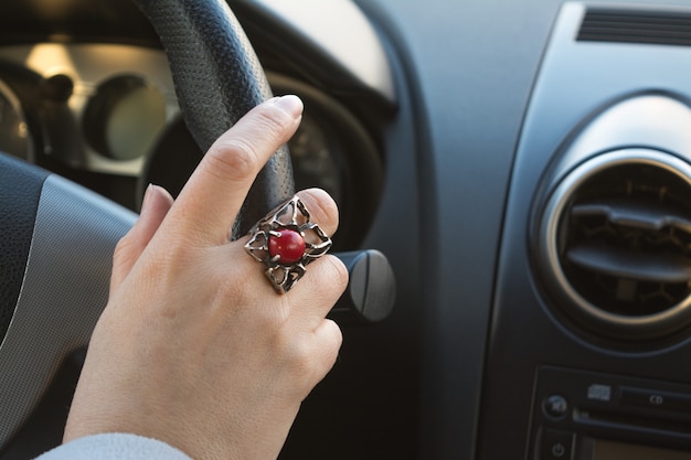 Hand der Frau auf dem Lenkrad eines Autos beim Fahren