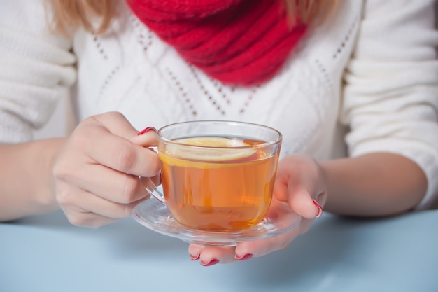 Hand der Frau, die Tasse Tee mit Stück Zitrone hält