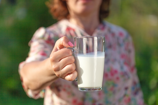 Hand der Frau hält ein Glas Milch