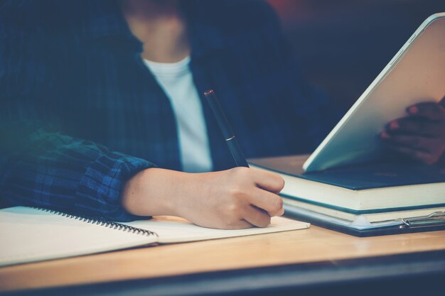 Hand der Geschäftsfrau, die Diagramm auf Finanzbericht mit Tablet zeigt. Konzept des zusammenfassenden Berichts