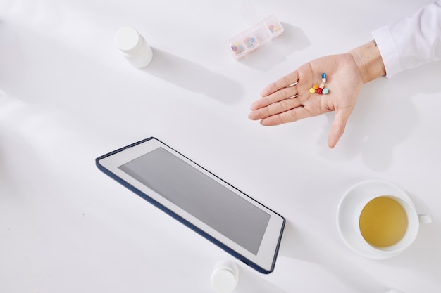 Hand des Arztes mit Pillen und Tabletten