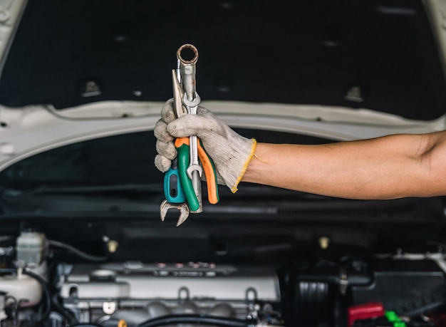 Hand des Automechanikers mit Schraubenschlüssel Automechaniker Reparaturwartung und Autoinspektion