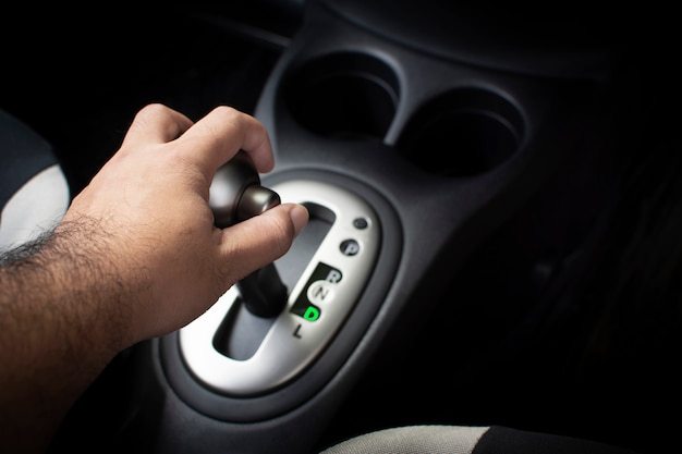 Hand des Fahrers setzen einen Schalthebel in Position D (Symbol) im Auto-Getriebewagen.