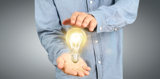 Hand des Haltens der belichteten Glühlampe, Innovationsinspiration
