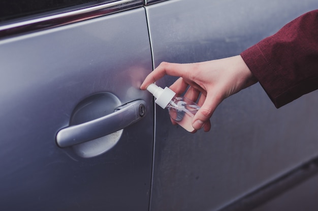 Hand des Mannes sprüht Desinfektionsspray