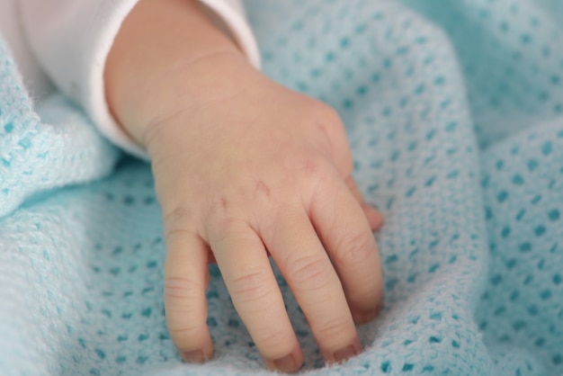 Foto hand des neugeborenen auf der blauen decke