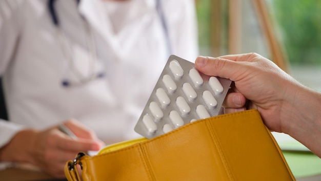 Hand des Patienten hält Blister mit medizinischer Pille und Tasche, die Medikamente und Anweisungen für verschreibt