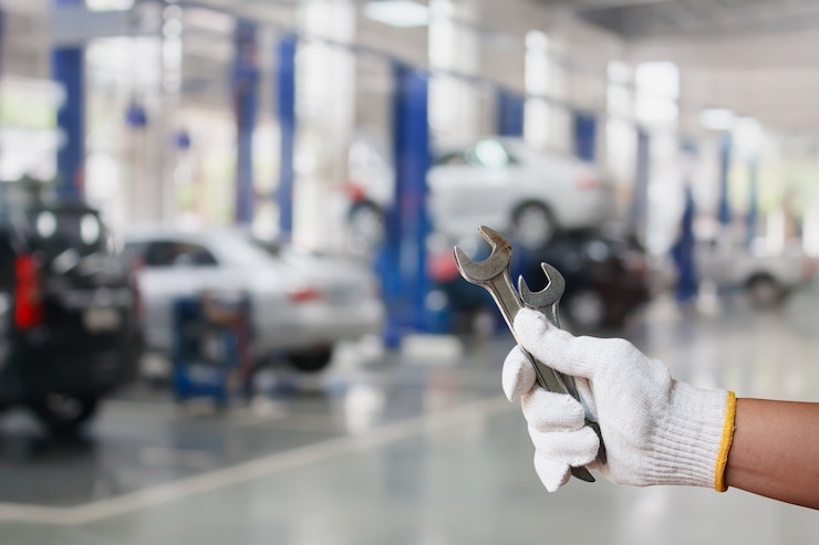 Foto hand des professionellen automechanikers mit schraubenschlüssel, autoreparaturservice
