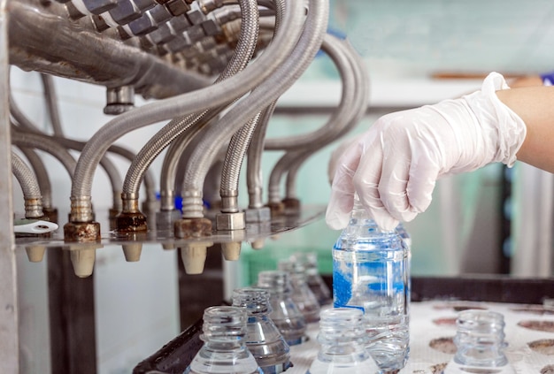 Foto hand des qualitätsinspektors wasserabfüllanlage zur verarbeitung und abfüllung von reinem trinkwasser