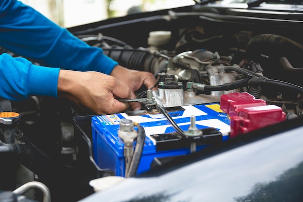 Hand des Technikers Motor des Autos überprüfend. Automechaniker, der Automotor überprüft.