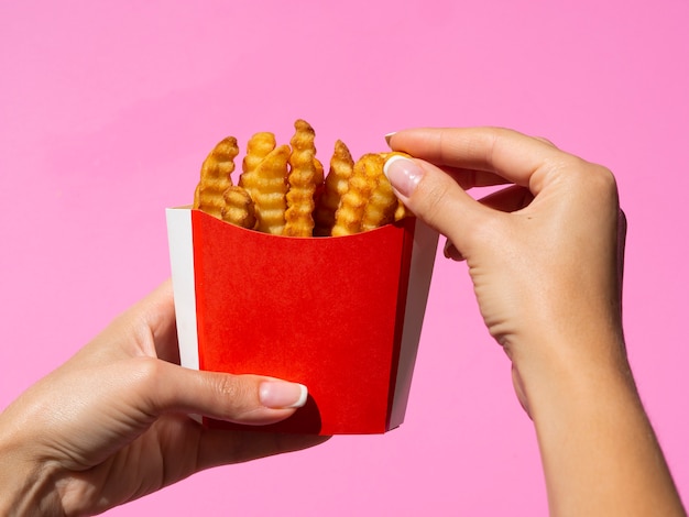 Hand, die amerikanische Fischrogen mit rosa Hintergrund ergreift