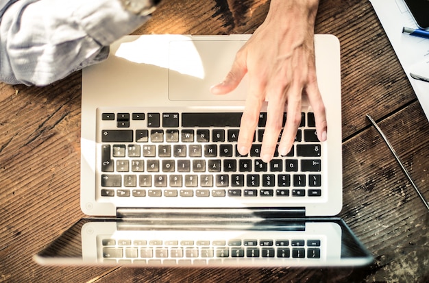 Hand, die auf einem Laptop schreibt