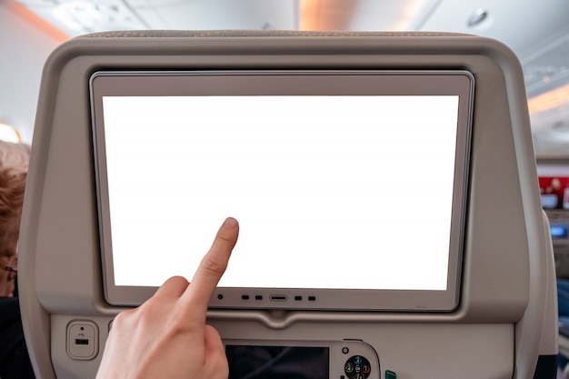 Hand, die auf weißem Bildschirm mit Steuerknüppel auf hinterem Sitz im Flugzeug sich berührt