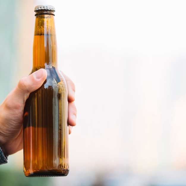 Foto hand, die bierflasche hält