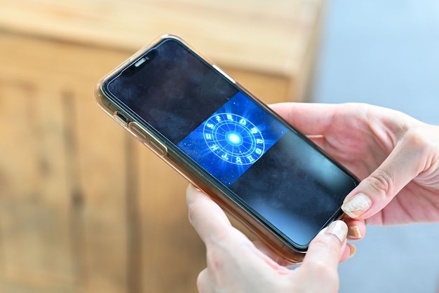 Hand, die das Smartphone überprüft Astrologisches Tierkreishoroskop Mobile Anwendung Spirituell neu