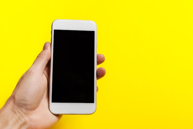 Hand, die das Telefon auf einem Beschneidungspfad mit gelbem Hintergrund im Inneren hält