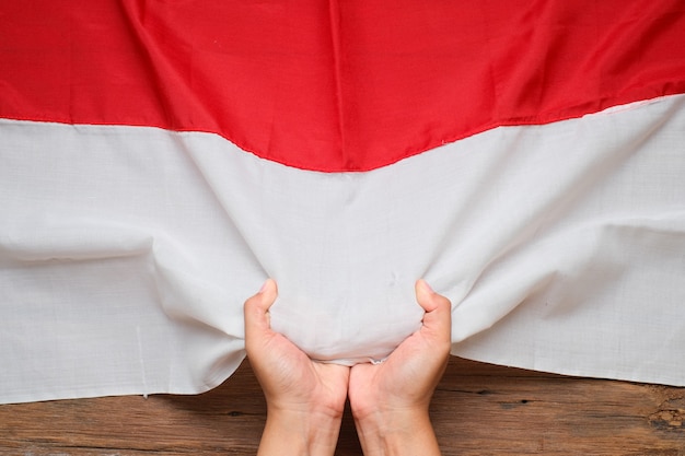 Hand, die die nationale indonesische flagge rot und weiß hält und berührt, konzept für den unabhängigkeitstag von indonesien