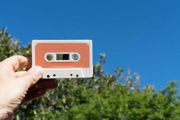 Hand, die draußen eine Audiokassette hält