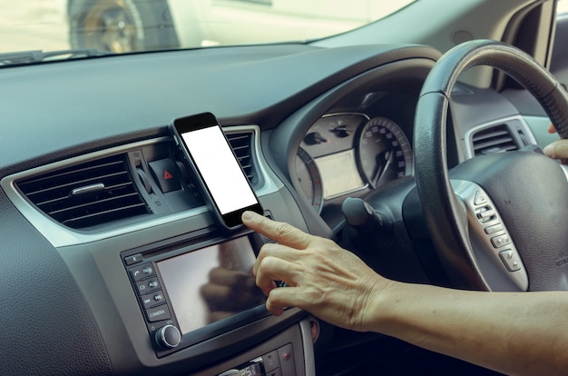 Hand, die ein Handy im Auto hält