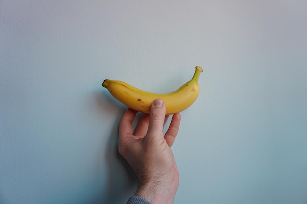 hand, die eine gesunde frucht der banane hält