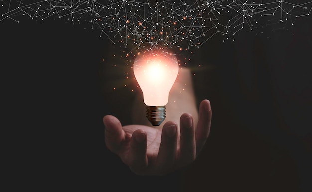 Hand, die eine leuchtende Glühbirne mit Verbindungsleitung für kreative Denkideen und Innovationskonzepte hält