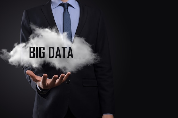 Hand, die eine Wolke mit den Wörtern Big Data auf dunklem Hintergrund zeigt.