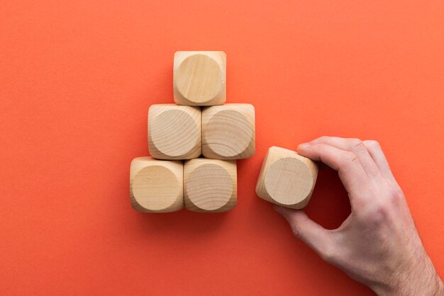 Hand, die einen Holzblock aus einem festgelegten Geschäftswahlkonzept auswählt