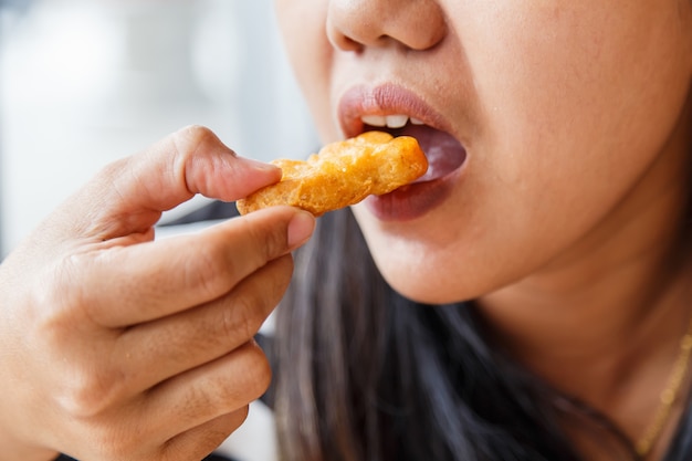 Hand, die Fried Chicken Nuggets hält und im Restaurant isst