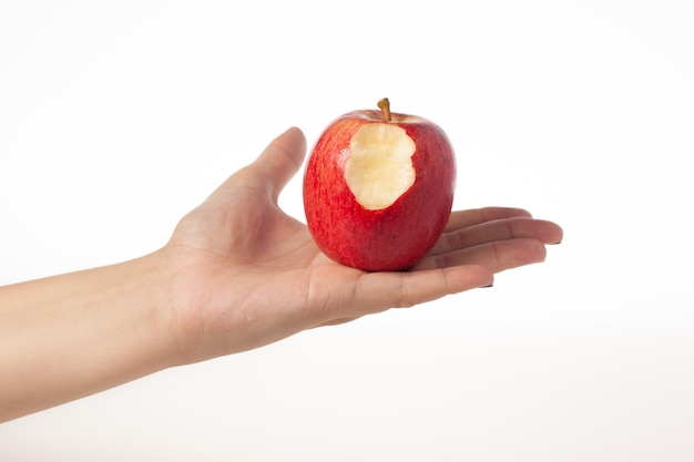 Hand, die gebissenen roten Apfel lokalisiert auf weißem Hintergrund hält