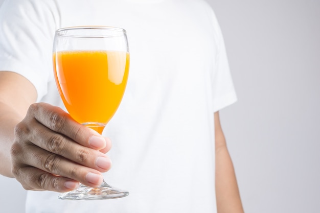 Hand, die Glas Orangensaft hält