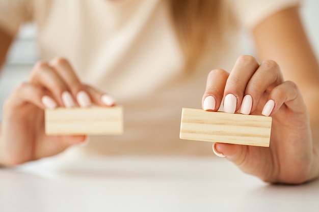 Hand, die leere Holzwürfel auf Tisch mit Kopierraum für Eingabetext und Infografik-Symbol setzt und stapelt.