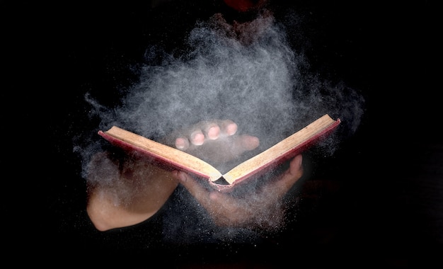 Hand, die mysteriöses altes Buch anhält