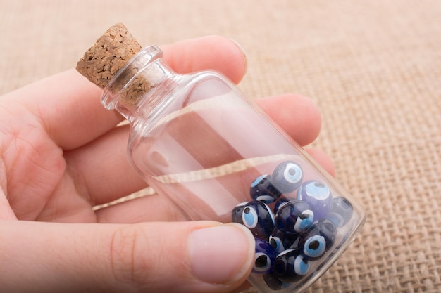 Hand, die Perle des bösen Blicks in der Flasche hält