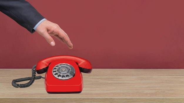 Hand, die rotes Telefon berührt