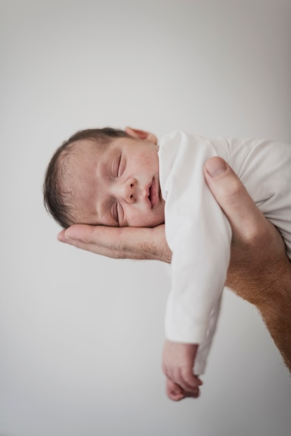 Hand, die schläfriges kleines Baby hält