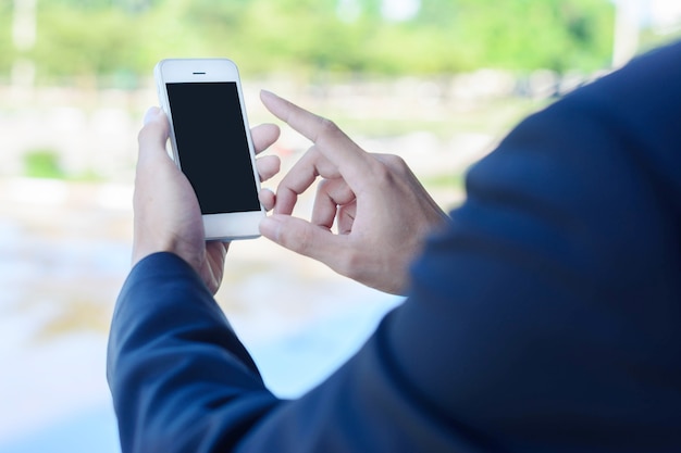 Hand, die Smartphone auf abstraktem Hintergrund hält