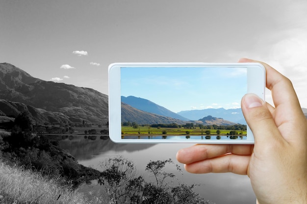 Hand, die Smartphone-Handy hält. Gemischte Medien