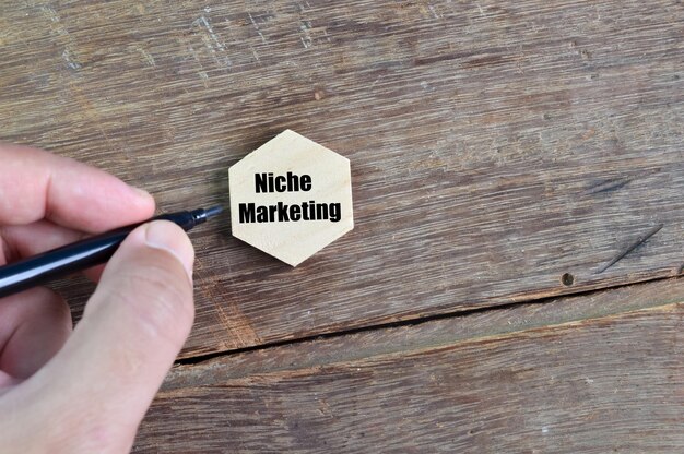 Foto hand, die stift hält und nische-marketing schreibt