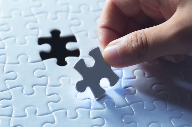 Foto hand, die stück des leeren puzzlen hält