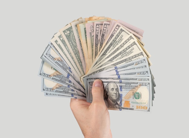 Hand, die US-100-Dollar-Scheine auf grauem Hintergrund hält Amerikanisches Geld