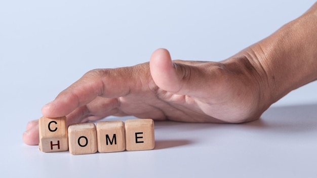 Hand, die Würfel mit Text zur Veranschaulichung von COME HOME-Wörtern hält